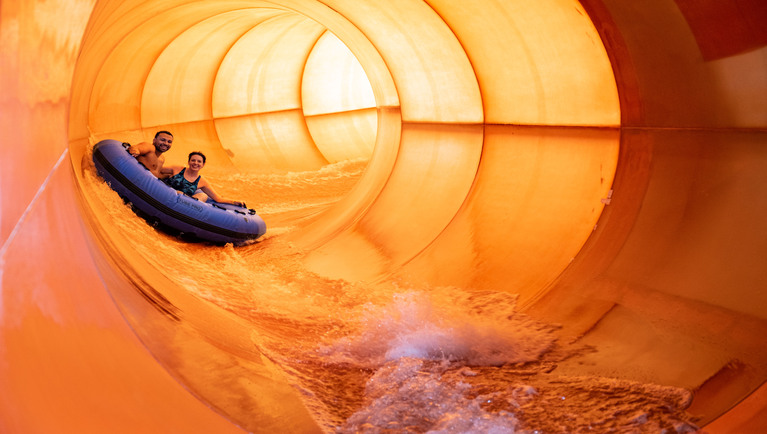 A family enjoys rafting together at Great Wolf Lodge indoor water park and resort.